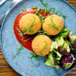 Overhead air fryer cooked arancini with an easy tomato sauce featuring a title overlay.