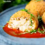 Air fryer arancini with an easy tomato sauce cut open to show filling featuring a title overlay.