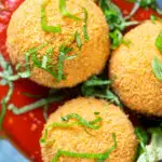 Overhead close-up air fryer cooked arancini with an easy tomato sauce featuring a title overlay.
