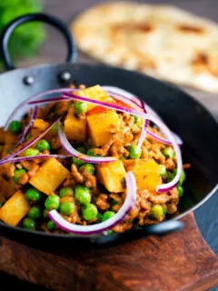 Aloo keema or Indian minced beef, pea and potato curry with red onion.