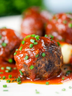 Close-up pork and black pudding meatballs with tomato sauce.