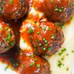 Close-up overhead Minced pork and black pudding meatballs with tomato sauce and snipped chives.