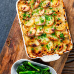 Overhead crispy potato-topped oven-baked creamy chicken and leek hotpot.