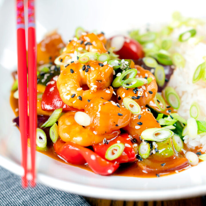 Chinese takeaway style sweet and sour prawns with plain rice and spring onions.