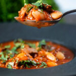 Fasolia, Lebanese-influenced lamb and butter bean stew one a spoon.