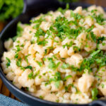 Homemade Hungarian nokedli dumplings with fresh parsley featuring a title overlay.