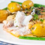Whole pan-fried lemon sole meuniere showing the texture of the cooked flesh featuring a title overlay.