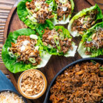 Chinese takeaway minced pork yuk sung stuffed in lettuce cups with fried noodles and peanuts.