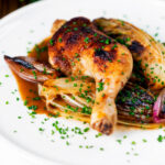 Baked chicken leg, Belgian endive and shallots with balsamic gravy and snipped chives.