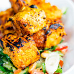 Salmon tikka served with a spicy cucumber salad with tomato, chilli and toasted peanuts.