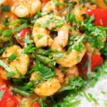 Close-up Thai shrimp panang curry with jasmine rice and fresh coriander.