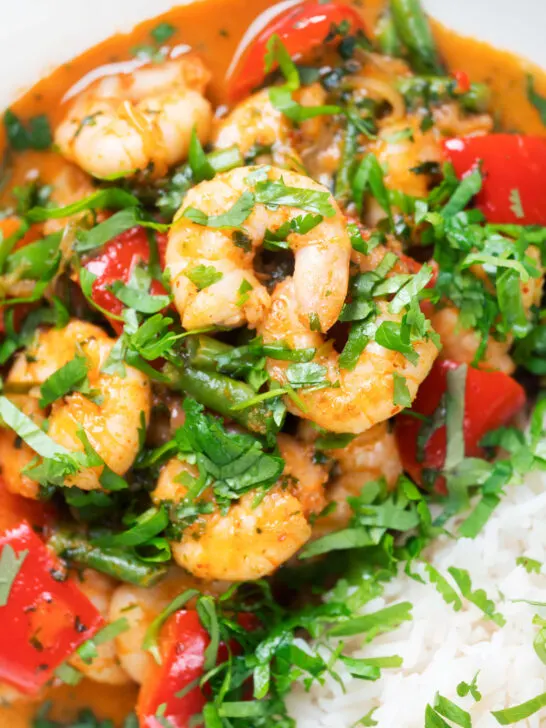 Close-up Thai shrimp panang curry with jasmine rice and fresh coriander.