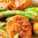 Close-up Thai red prawn curry with green beans served with rice.