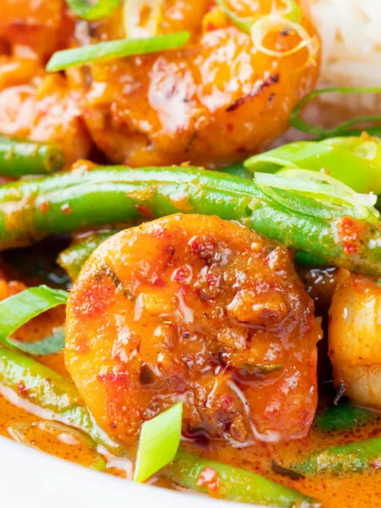 Close-up Thai red prawn curry with green beans served with rice.