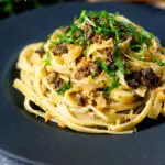 Tuna pesto pasta with crispy capers, golden breadcrumbs and fresh basil featuring a title overlay.