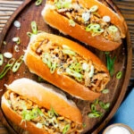 Overhead Japanese yakisoba pan, stir-fried udon noodles served in a hot dog bun.