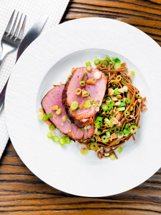 Overhead baked tuna steak with a honey and soy glaze served with a soba noodle salad.