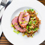 Overhead baked tuna steak with a honey and soy glaze served with a soba noodle salad featuring a title overlay.