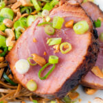 Close-up baked tuna steak with a honey and soy glaze served with noodle salad.