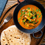 Overhead Sri Lankan influenced chicken Ceylon curry with homemade chapatis.