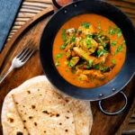 Overhead Sri Lankan influenced chicken Ceylon curry with homemade chapatis.