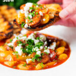 Chorizo and butterbean stew with crumbled feta cheese being eaten with toast featuring a title overlay.