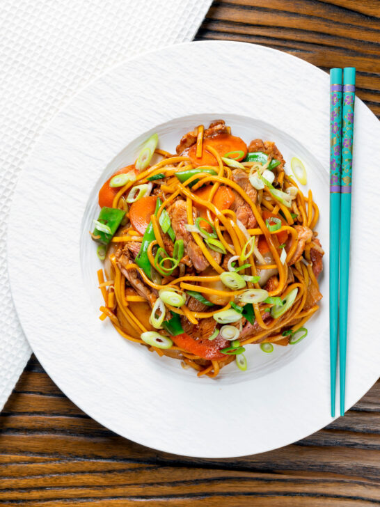 Overhead hoisin duck chow mein stir fry with noodles, carrots and runner beans.