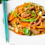 Hoisin duck chow mein stir fry with noodles, carrots and runner beans.