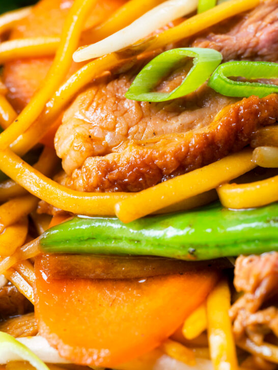 Close-up hoisin duck chow mein stir fry with noodles, carrots and runner beans.