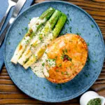 Overhead individual ham and apple fidget pie with a cider cream sauce.