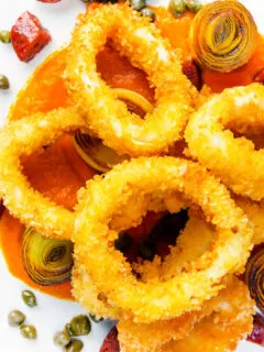 Overhead fried and breaded calamari rings with romesco sauce, leeks, chorizo and capers.