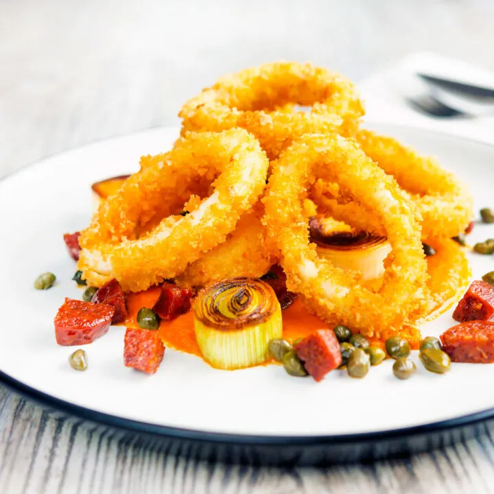 Crispy fried and breaded calamari rings served with romesco sauce, fried chorizo and capers.