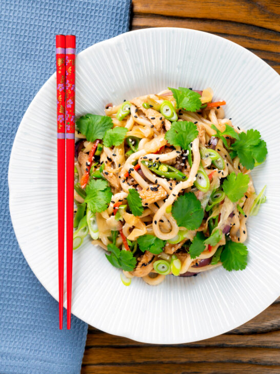 Overhead ginger chicken udon noodle stir fry with chilli and spring onions.