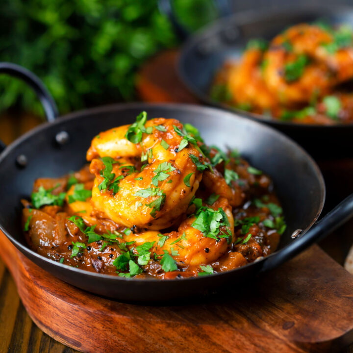 Indian king prawn bhuna served with fresh coriander in an iron kadai.