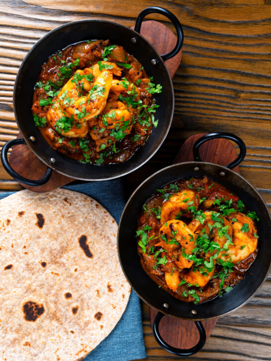 Overhead king prawn or shrimp bhuna served with chapatis and fresh coriander.