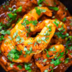 Close-up overhead king prawn or shrimp bhuna served with fresh coriander.