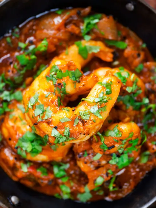 Close-up overhead king prawn or shrimp bhuna served with fresh coriander.