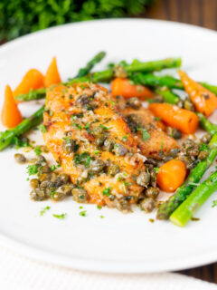 Lemon and caper chicken breast piccata served with asparagus and carrots.