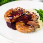 Minted lamb chops with red wine sauce, mashed potato and asparagus featuring a title overlay.
