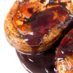 Close-up minted lamb chops with red currant jelly and red wine sauce.