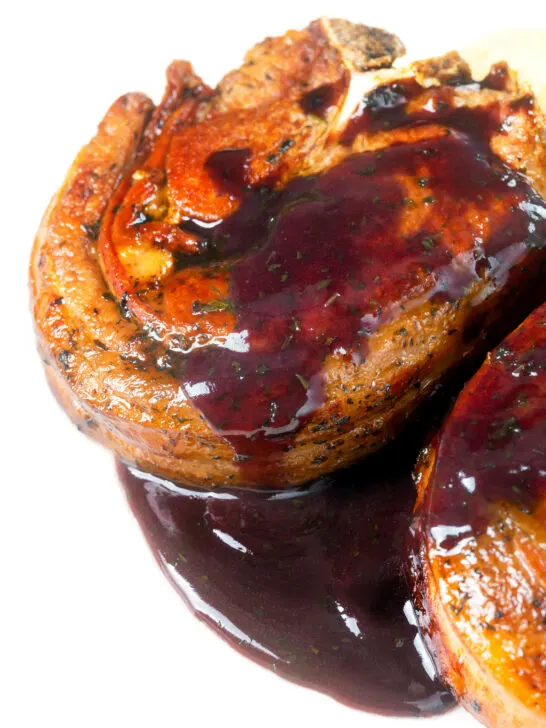 Close-up minted lamb chops with red currant jelly and red wine sauce.