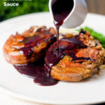 Rich red wine sauce being poured over pan-fried minted lamb chops featuring a title overlay.