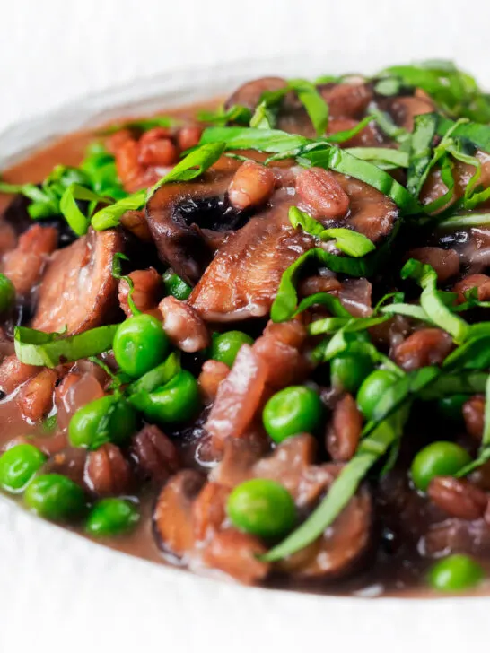 Close-up Vegetarian mushroom pearled barley risotto or orzotto cooked with red wine and peas.