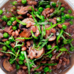 Close-up overhead mushroom pearled barley risotto or orzotto cooked with red wine and peas.