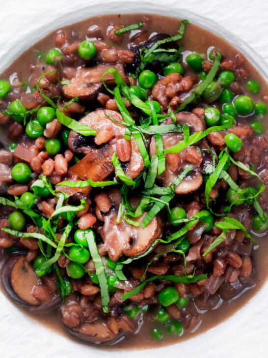 Close-up overhead mushroom pearled barley risotto or orzotto cooked with red wine and peas.