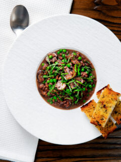 Overhead mushroom pearl barley risotto or orzotto cooked with red wine and peas.