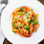 Overhead spicy nduja pasta made with Fiorelli, tomatoes and fresh basil.