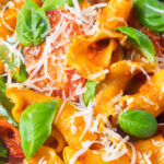 Close-up spicy nduja pasta made with Fiorelli, tomatoes and fresh basil.