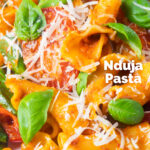 Close-up spicy nduja pasta made with Fiorelli, tomatoes and fresh basil featuring a title overlay.