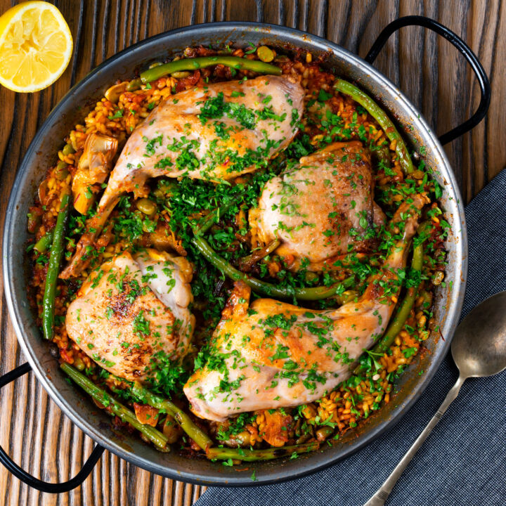 Traditional paella Valenciana is made with rabbit and chicken with green beans and artichokes.